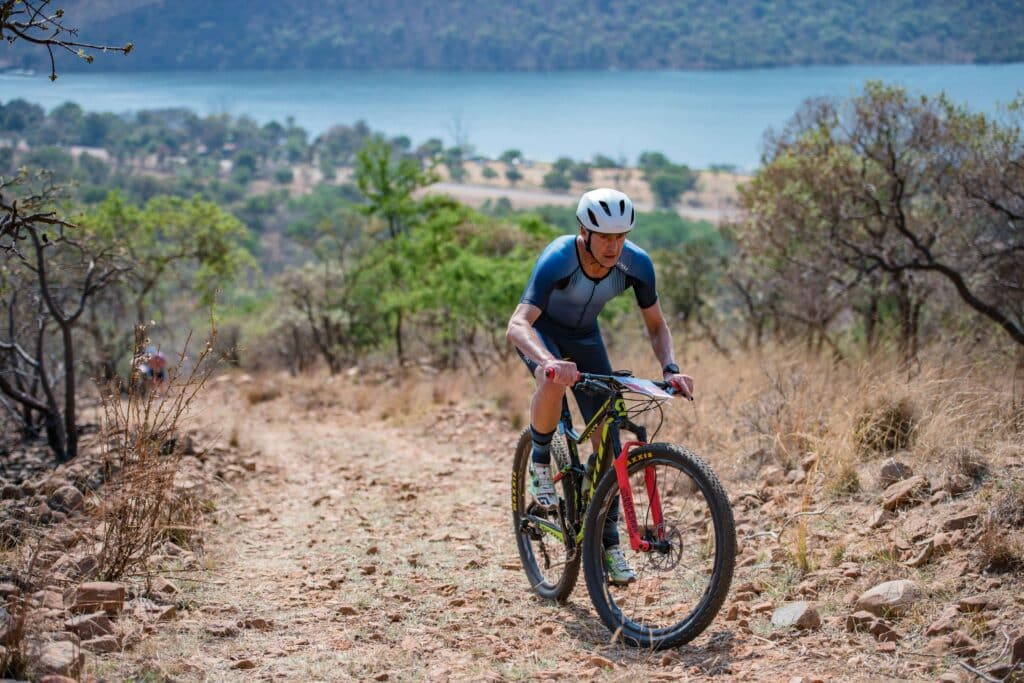 South African Off Road Triathlon In Gauteng At Buffelspoort Cyclist Climbs A Hill