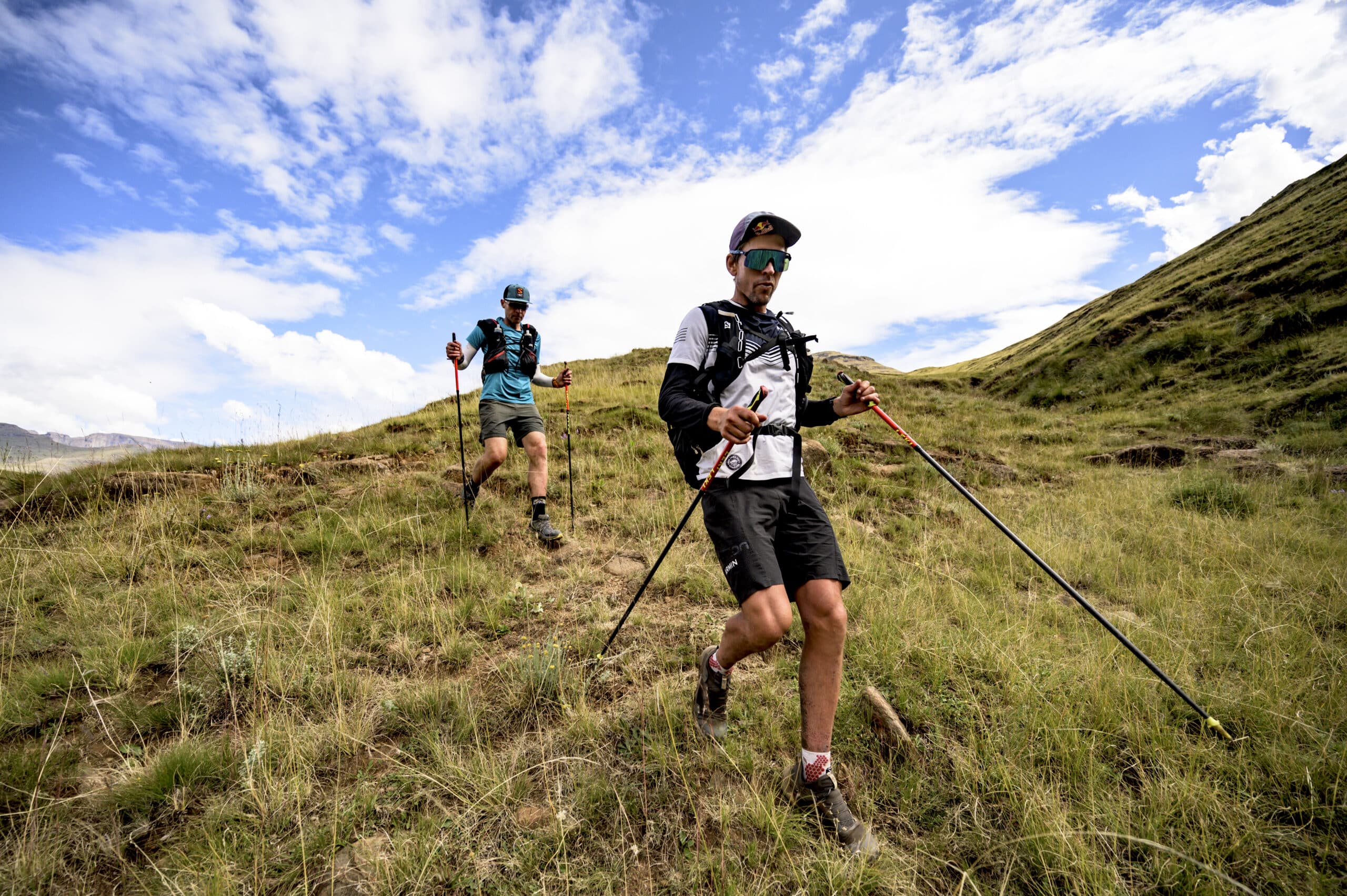 Ryno Griesel and Ryan Sandes with hydration packs and running poles for trail running